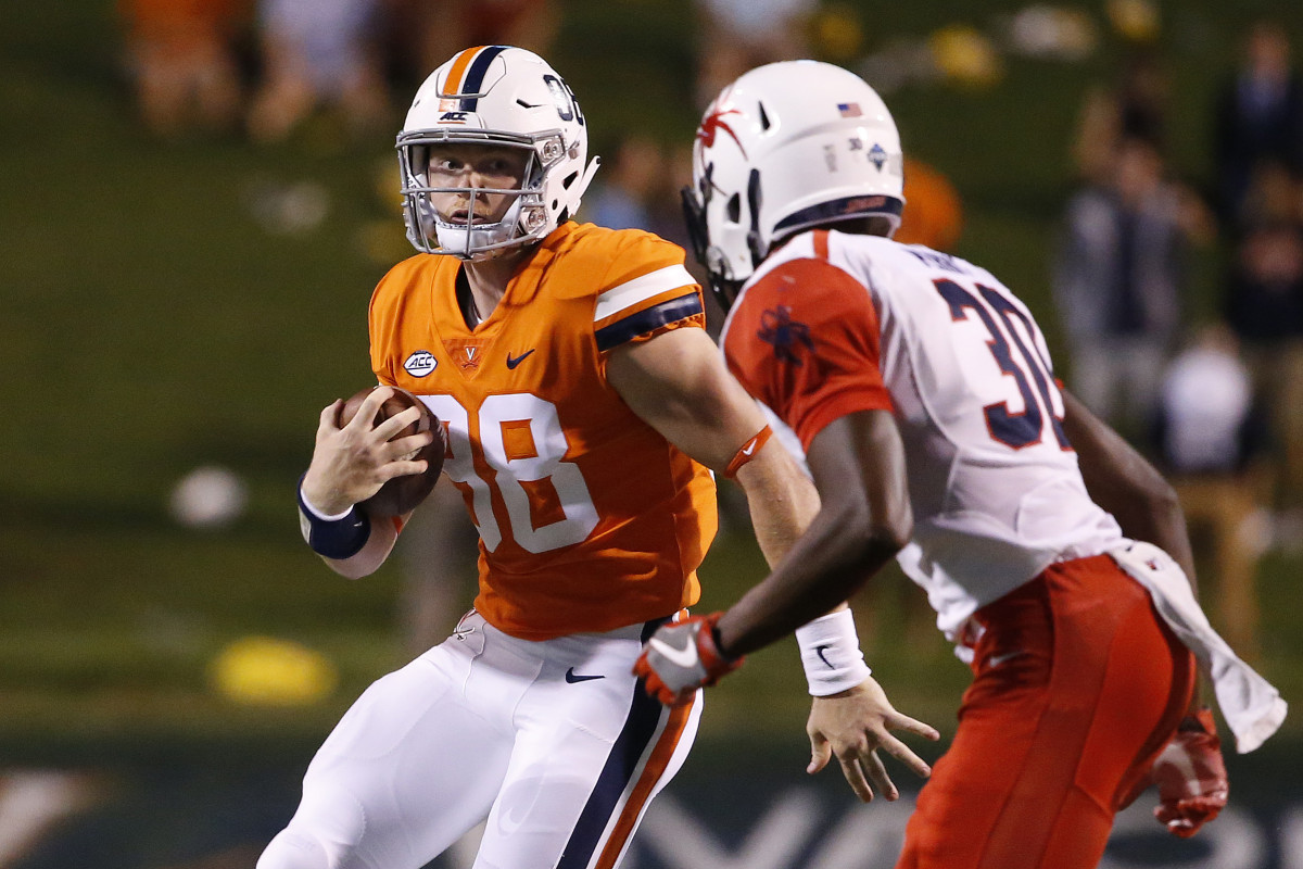 Virginia Cavaliers quarterback Brennan Armstrong (98) runs with the ball as Richmond Spiders defensive back Devon Perry (30) defends during the second half at Scott Stadium.